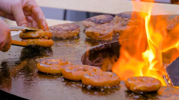Chef grelhando salsichas de porco em espiral fresco no braseiro com chama quente — Fotografia de Stock