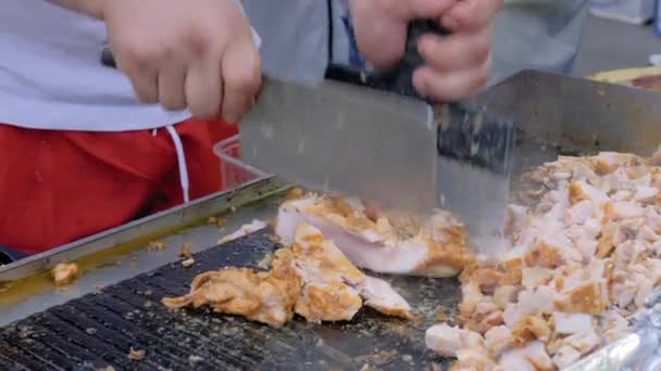 Slow motion: chef cutting chicken meat on grill at street food festival — Stock Video