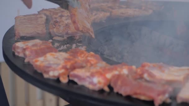 Zpomalený film: šéfkuchař s kleštěmi grilující masové steaky na pánvi s horkým plamenem — Stock video