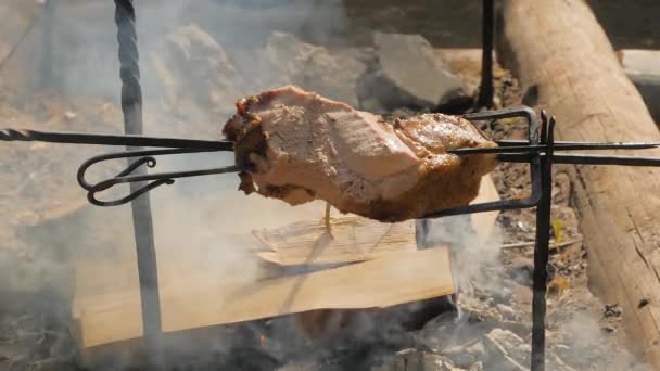 Slow motion: process of cooking large meat peaces on spit over open fire — Stock Video