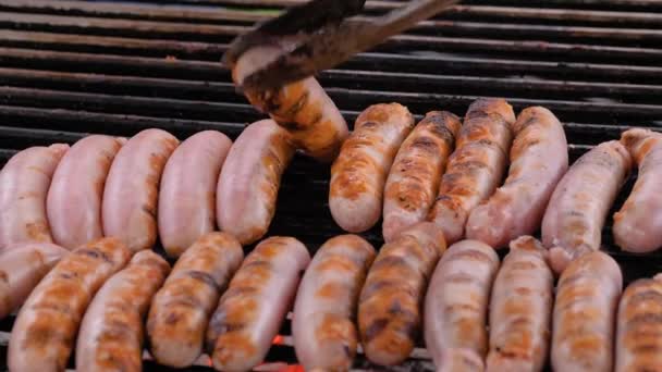 Lambat gerak: koki memanggang daging segar sosis pada putaran besar tergantung panggangan — Stok Video