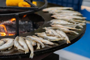 Avrupa yemekleri pişirme süreci, gıda festivalinde siyah brazier üzerinde balık eridi.