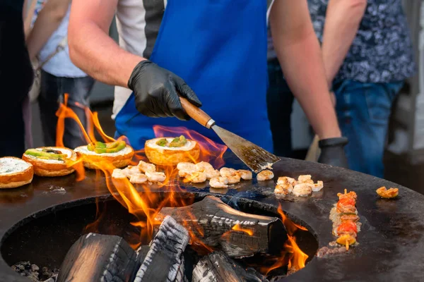 Chef-kok bereidt visburgers op outdoor street food festival - close-up — Stockfoto