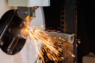 Lazer kesme makinesi, silindirik metal kıvılcımlarla çalışıyor.