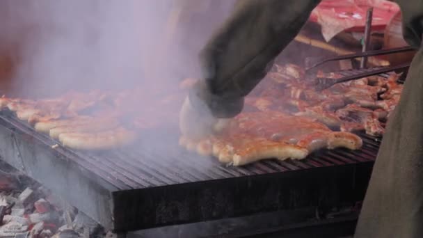 Повільний рух: два кухарі смажать яловичину або свинячі ребра, ковбаски на мангалі: крупним планом — стокове відео