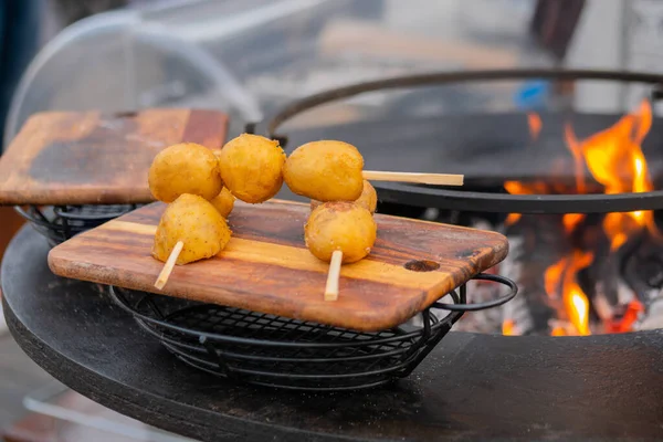 Krispigt gult potatisspett på träskärbräda på matfestivalen — Stockfoto