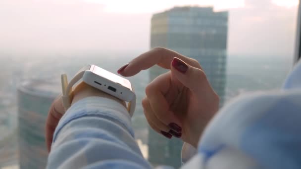 Frauenhand mit tragbarer weißer Smartwatch im Büro - Seitenansicht aus nächster Nähe — Stockvideo