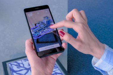 Artırılmış gerçeklik uygulaması olan akıllı telefon kullanan kadın AR konsepti