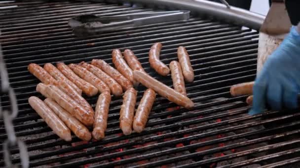 Närbild - kock grilla färskt kött korv på stora runda hängande grill — Stockvideo