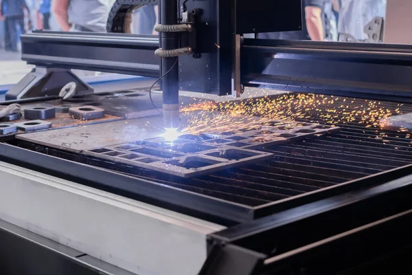 Plasma cutting machine working with sheet metal with many bright sparks