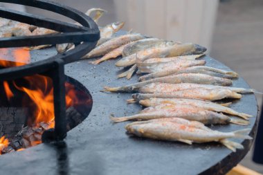 Avrupa yemekleri pişirme süreci, gıda festivalinde siyah brazier üzerinde balık eridi.