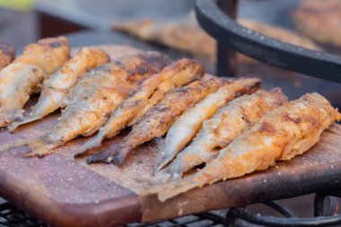 Çıtır ekmekli Avrupa balığı, yemek festivalinde ahşap kesme tahtasının üzerinde eridi.