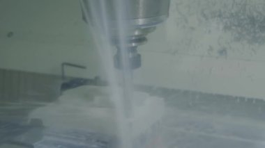 Fabrikada metal işçiliği kesen soğutma sistemi olan bir değirmen makinesi.