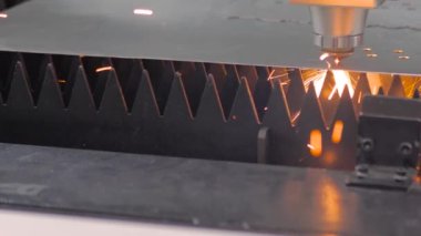 Lazer kesme makinesi fabrikada kıvılcımlarla metal levha ile çalışıyor.