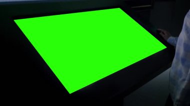 Yeşil ekran konsepti - Sergide boş yeşil ekran kioskuna bakan kadın