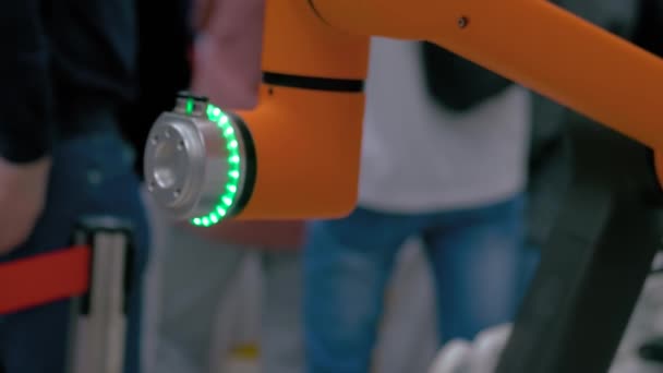 Oranje collaboratieve robot beweegt en werkt in demo-modus op robotexpo — Stockvideo