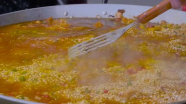 Yavaş çekim: Aşçı kızarmış tavuklu paella pişiriyor, pilav, sebze - yakın çekim