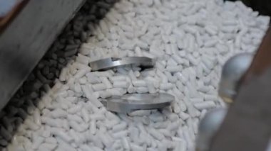 Aşındırıcı taşlarla metal işçilikleri parlatan bir vibratör makinesi.