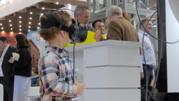 Petit garçon utilisant un casque de réalité virtuelle à l'exposition technologique VR — Video