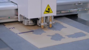 Flatbed kesicisi, çizici yazıcı sergisinde karton yaprak kesiyor
