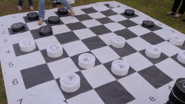 Woman and little boy playing giant checkers at summer outdoor festival — Stock Video