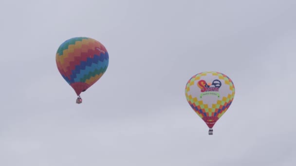 Gri kış gökyüzünde uçuşan renkli sıcak hava balonları — Stok video