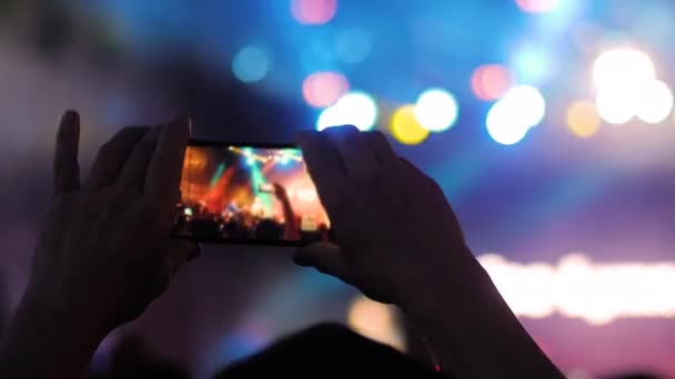 Close up: mãos de homem gravando vídeo de concerto de música ao vivo com smartphone — Vídeo de Stock