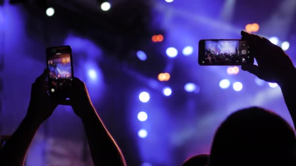 Pessoas mãos gravação de vídeo de concerto de música ao vivo com smartphone à noite — Vídeo de Stock