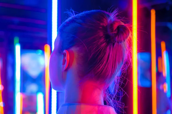 Portrait of woman looking around at exhibition or museum with colorful light