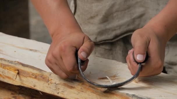 Slow motion: man snickare med hjälp av dragkniv för att forma och släta träskiva — Stockvideo