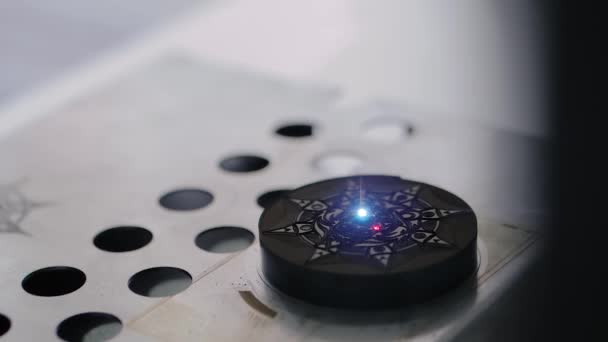 Máquina de grabado láser signo ardiente de estrella en pieza de plástico circular — Vídeos de Stock