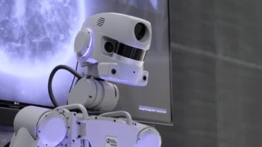 Yakın plan: İnsansı robot Fedor hareket ediyor, uzay sergisine bakıyor