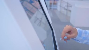 Sergide dokunmatik kiosk ekranı kullanan kadın eli