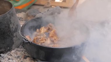 Ağır çekim: elinde spatula olan bir adam tavada et kızartıyor- yakın çekim