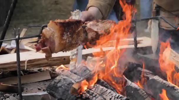 Cámara lenta: proceso de cocción de grandes peaces de carne en escupir sobre fuego abierto — Vídeos de Stock