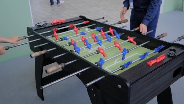 スローモーション:テーブルサッカーゲームをプレイする男と女-トレードショーでのサッカー — ストック動画