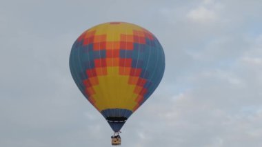 Bulutlu kış gökyüzünde uçan renkli sıcak hava balonu