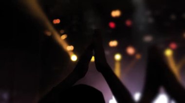 Gece rock konserinde eğlenen ve alkışlayan insanların siluetleri.