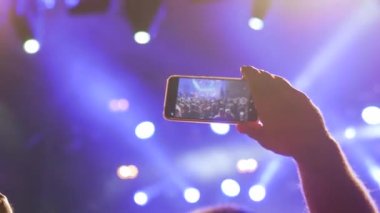 Yakın çekim: Adam akıllı telefonlu canlı müzik konseri videosu kaydediyor