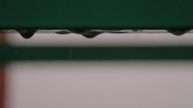 Ağır çekim - Metal çatı deposundan düşen ağır yağmur damlaları - kapatın