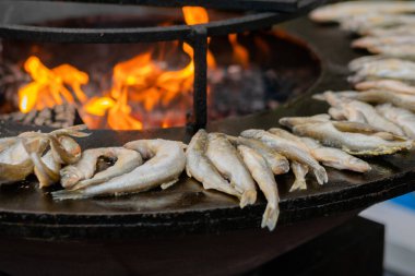 Avrupa yemekleri pişirme süreci, gıda festivalinde siyah brazier üzerinde balık eridi.
