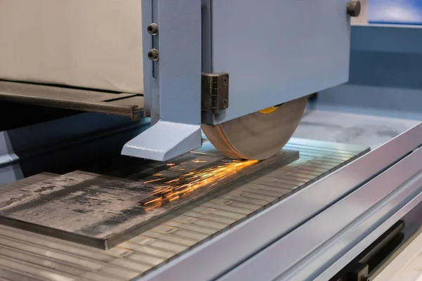 Yüzey öğütücü tekerlek makinesi fabrikada kıvılcımlı levha metalle çalışıyor.