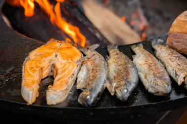 Izgara somon bifteği ve siyah Brezilya uskumrusu üzerine uskumru balığı. Yaklaş.