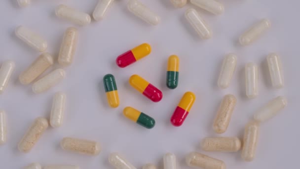 Таблетки, таблетки, лекарства, лекарства, вращающиеся на белой поверхности - крупным планом — стоковое видео