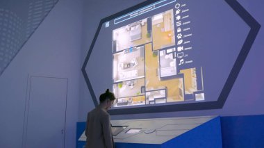 Modern teknoloji sergisinde etkileşimli dokunmatik ekran kullanan kadın