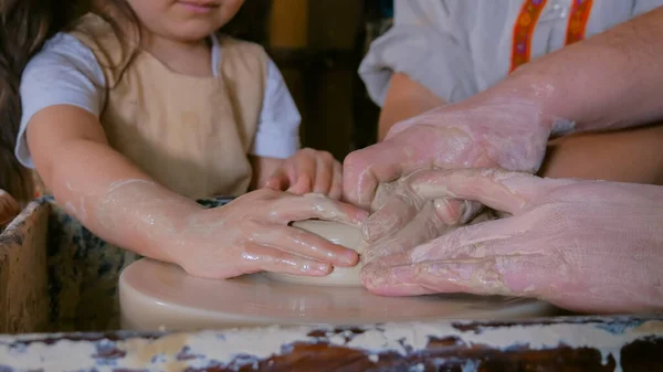 Potter showing how to work with ceramic in pottery studio