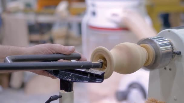 Långsam rörelse: timmerman använder stämjärn för att forma träbit på svarv: närbild — Stockvideo
