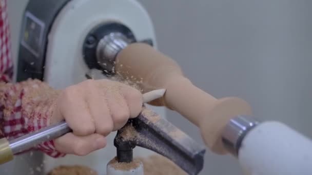 Närbild: tonårspojken använder stämjärn för att forma trästycket på svarv: slow motion — Stockvideo