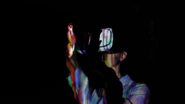 Молода жінка використовує гарнітуру віртуальної реальності на темній інтерактивній виставці VR — стокове відео
