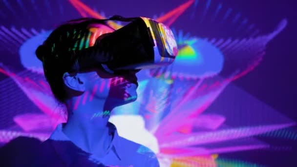 Mladá žena používající sluchátka virtuální reality na temné interaktivní výstavě VR — Stock video